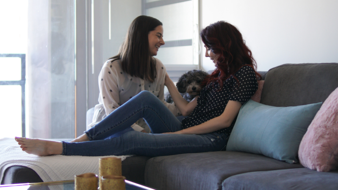 Lesbian Couple with Cute Dog on Couch