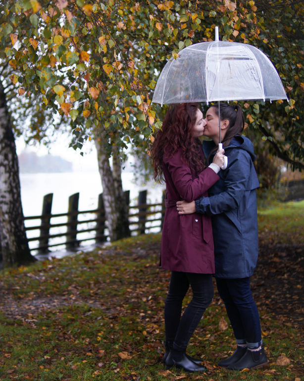 Lesbian couple kiss under umbrella